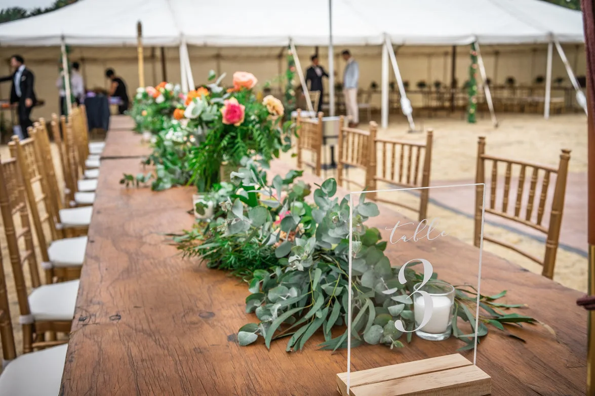 Rustic timber table with eucalyptus and bloom runner set for an outdoor reception
